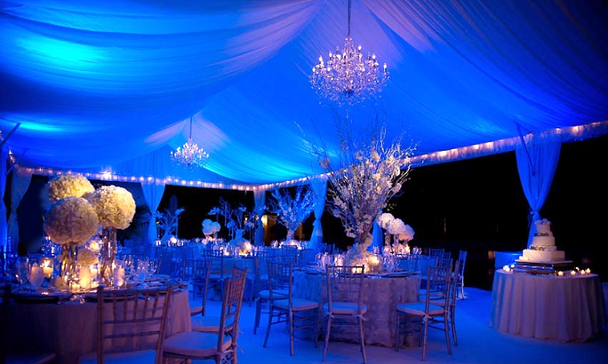 Blue light washes the canopy above a chandelier